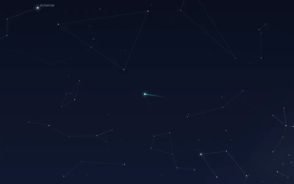 A close-up of a dark blue night sky with faint constellation lines and scattered small stars. In the middle, a white point with a short cyan trail running off to its right. A bright star at the top left is labelled Achernar.